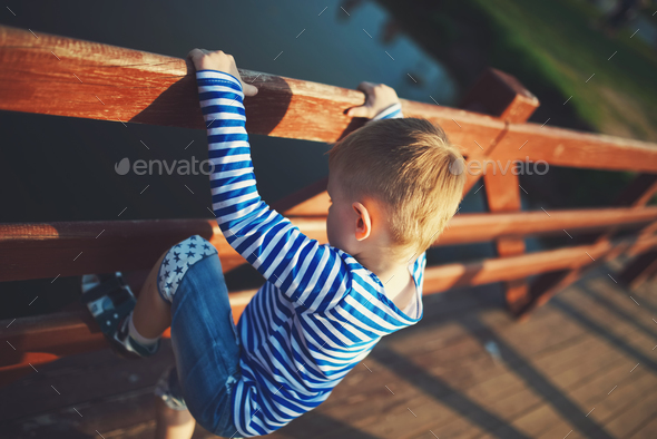 little boy climbing over the fence Stock Photo by ababaka | PhotoDune