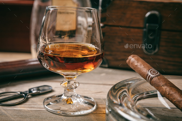 Cuban cigar and a glass of brandy on wooden background, closeup view with  details Stock Photo by rawf8