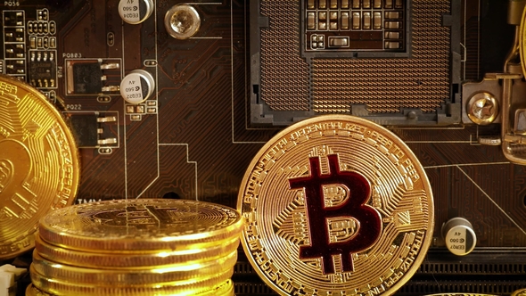 Gold Bit Coin BTC Coins on the Motherboard. Bitcoin Is a Worldwide Cryptocurrency alt