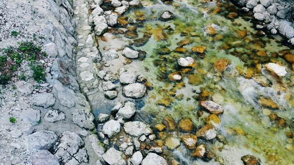 Top View of Stones Getting Bathed By a Flow of Stream Water alt