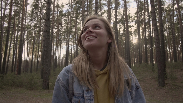 Happy Girl Standing in the Sunny Forest and Smile alt