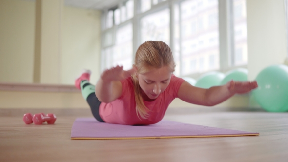 The Girl Is Doing Exercises for the Muscles of the Back. alt