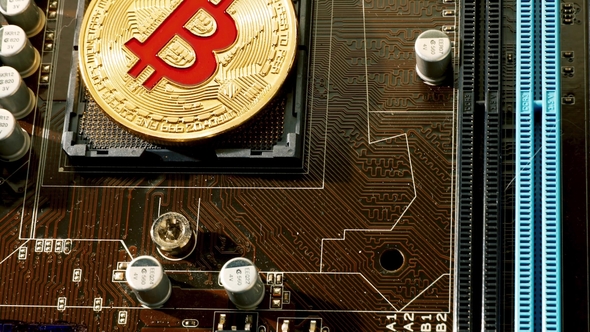 Gold Bit Coin BTC Coins on the Motherboard. Bitcoin Is a Worldwide Cryptocurrency alt