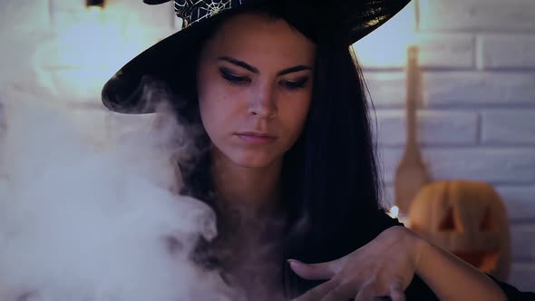 Beautiful Woman in Witch Costume Making Magic Potion, Preparing for Halloween alt