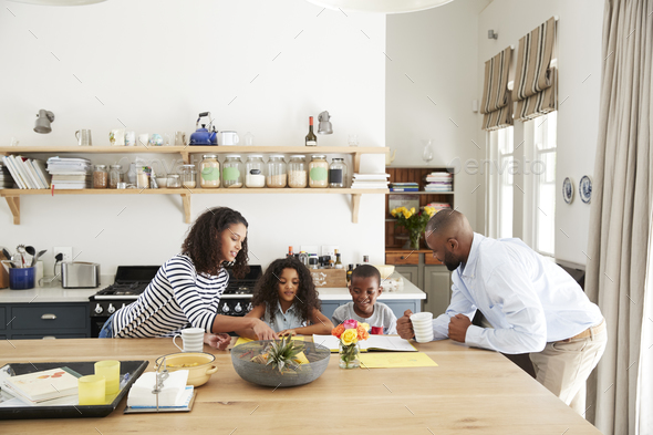 Young black family busy together in their kitchen Stock Photo by monkeybusiness