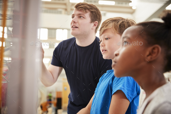 Teacher and kids looking at a science exhibit, close up Teacher and kids looking at a science exhibit, close up