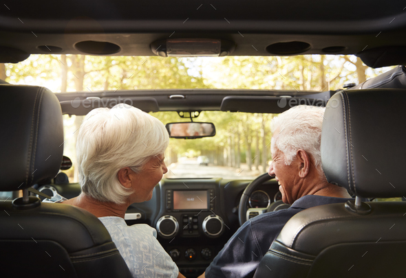 Senior Couple Drive Open Top Car On Countryside Road Trip Stock Photo by monkeybusiness