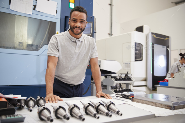 Portrait Of Male Engineer With CAD Drawings In Factory Stock Photo by monkeybusiness