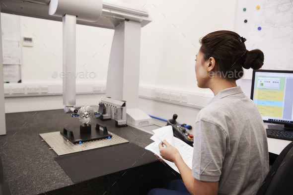 Female Engineer Uses CMM Coordinate Measuring Machine In Factory Stock Photo by monkeybusiness