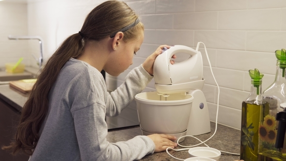 Little Girl Mixing Dough in Mixer in Kitchen