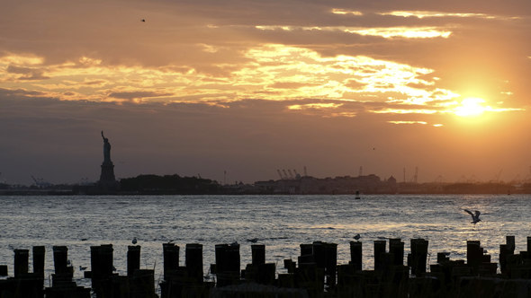 Sunset at the Pier on the East River with silhouette of the Statue of Liberty