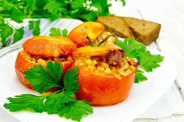 Tomatoes stuffed with bulgur and parsley in plate on board - Stock Photo - Images