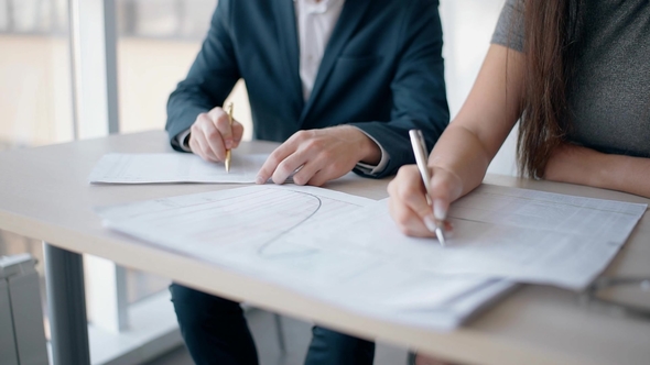 Young Man and Woman Working on New Project Sitting at Office Table ...