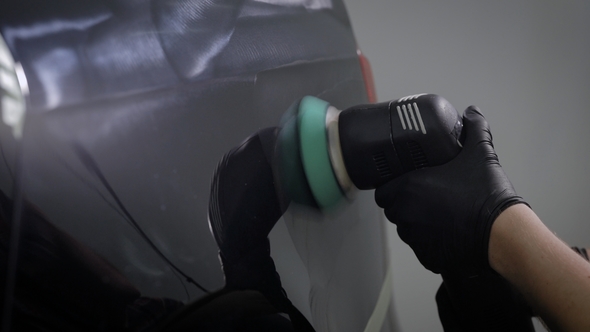 Man Is Spreading Gloss Over Surface of Black Auto with Rotating Electric Polishing Machine, alt