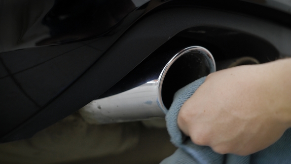 Man Is Wiping, Cleaning and Polishing By Cloth Chrome Exhaust Pipes of Modern Automobile, alt
