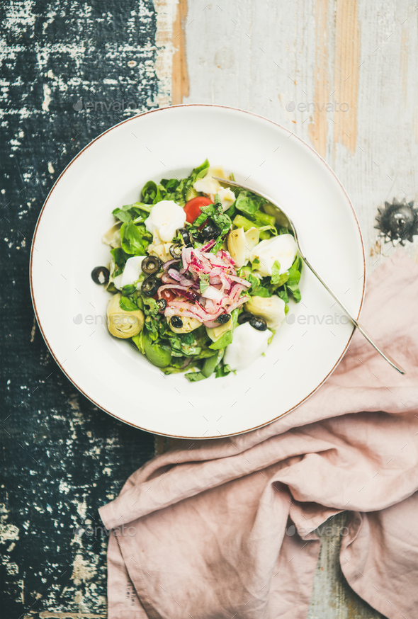 Fresh green summer salad with artichokes over wooden painted background - Stock Photo - Images