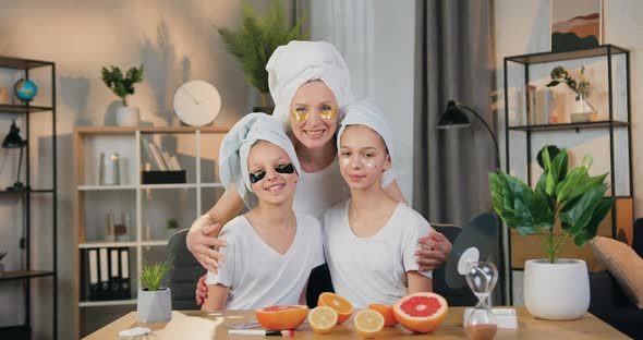 Mother Hugging Her Two Teen Daughters while they All Applying Hydrogel Refreshing Eye Patches alt
