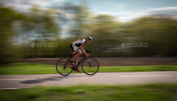 Cyclist rides on bicycle, speed effect, side view - Stock Photo - Images