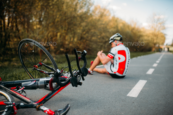 Male bycyclist fell off bike and hit his knee Stock Photo by NomadSoul1