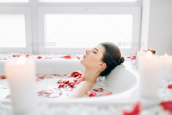 Woman sleeps in the bath with foam, rose petals Stock Photo by NomadSoul1