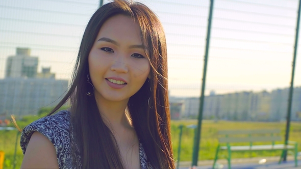 Asian Girl with Beautiful Smile and Long Hair Posing in Front of Camera