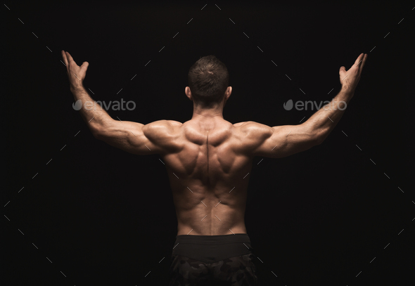 Unrecognizable man shows strong back muscles closeup Stock Photo by Prostock-studio