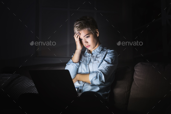 Tired woman with laptop at dark office copy space Stock Photo by Prostock-studio