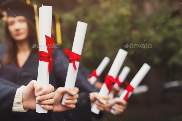 Group of students holding diplomas, copy space Stock Photo by Prostock-studio