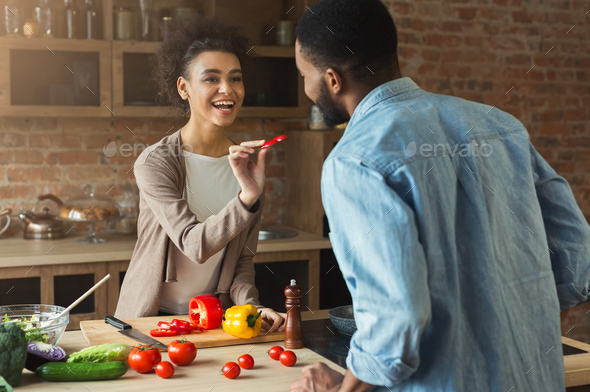 Happy black couple cooking healthy food together Stock Photo by Prostock-studio