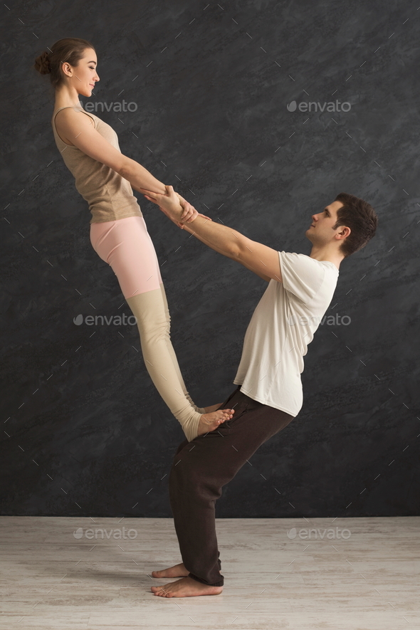 Young couple practicing acroyoga on mat together - Stock Photo - Images
