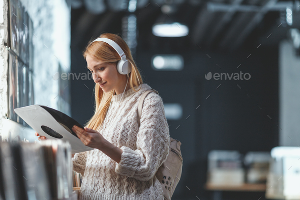 Attractive woman with headphones in a store Stock Photo by AboutImages