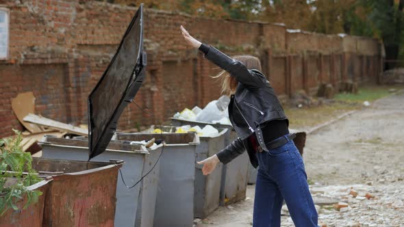 Woman Throws Broken Modern TV Into Trash Cans Concept of Getting Rid of TV Addiction alt