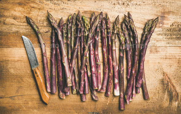 Fresh purple asparagus over wooden background - Stock Photo - Images