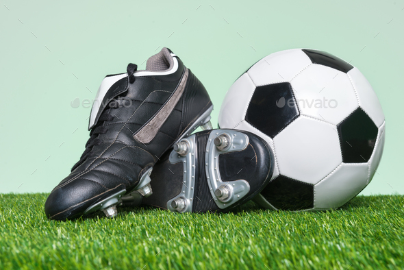 Football or Soccer boots and ball on grass Stock Photo by RTimages