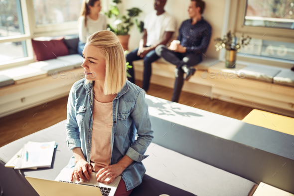 Young businesswoman deep in thought while working on a laptop - Stock Photo - Images