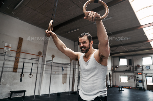 Young man smiling during a ring workout at the gym Stock Photo by  FlamingoImages