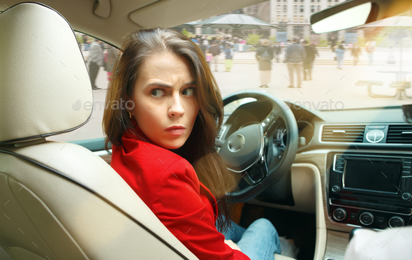 Driving around city. Young attractive woman driving a car Stock Photo by master1305