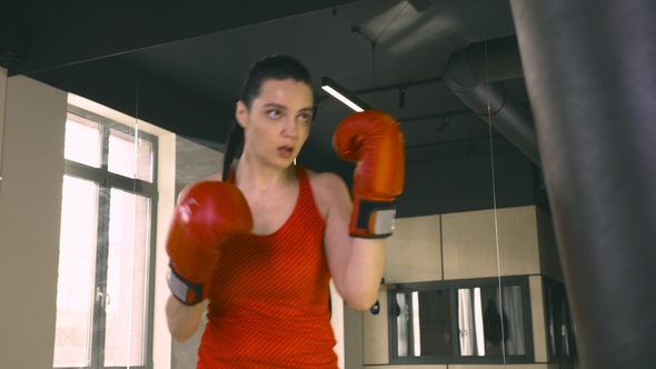 Young Woman Hitting a Boxing Bag alt