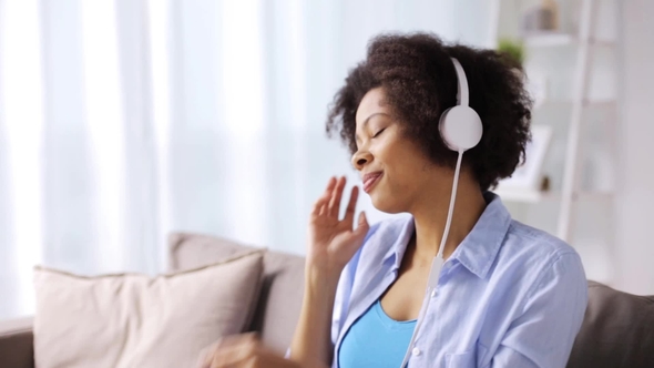 Woman with Headphones Listening To Music at Home alt
