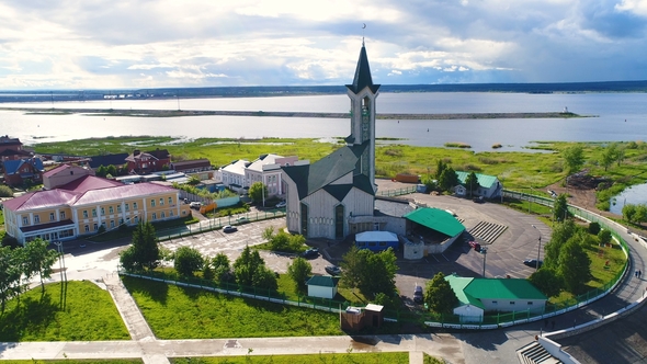Modern Mosque with High Minaret Against Sky and Lake alt