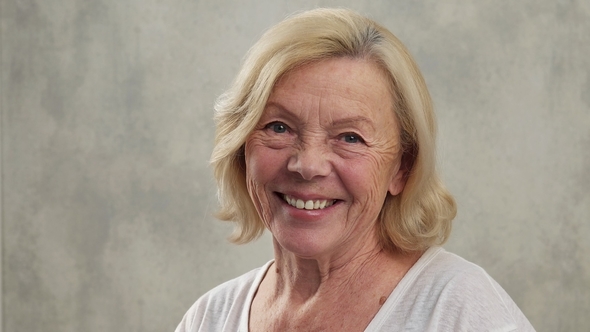 Satisfied Senior Woman Turns Her Head Smiling and Looking at Camera