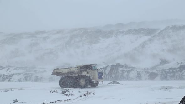 A Dumper Truck Drives Through an Open-pit Coal Mine in Winter