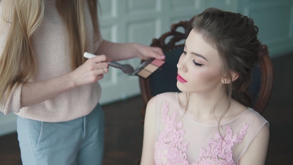 Stylist Does Makeup of the Model. the Girl in a Cocktail Dress Is Getting Ready for the Celebration