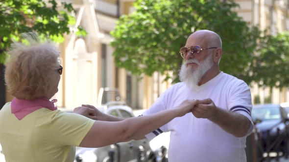Senior Couple Enjoy Each Other and Dancing Waltz at Urban Street alt