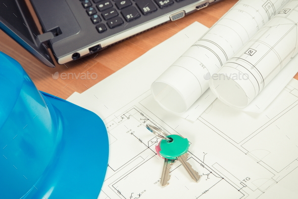 Home keys, electrical diagrams with laptop for engineer jobs and protective blue helmet Stock Photo by ratmaner