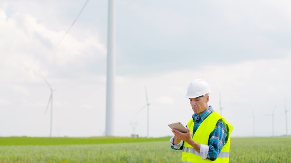 Engineer Using Digital Tablet When Doing Wind Turbine Inspection alt