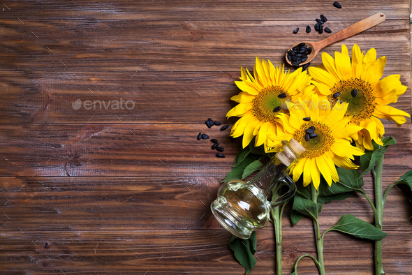 yellow sunflowers with oil glass bottle on background of old fence. Stock Photo by lyulkamazur