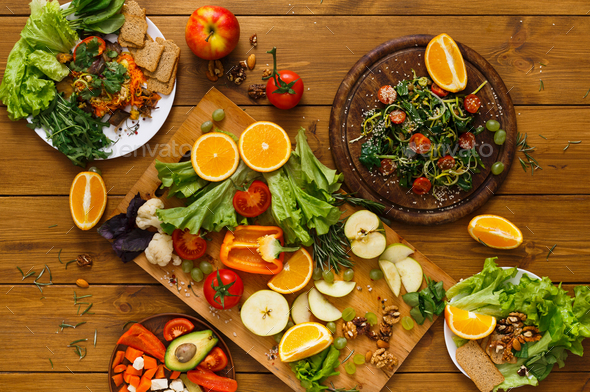 Wooden table served with cut fruits and vegetables Stock Photo by Prostock-studio
