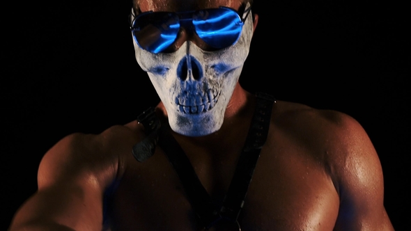 Man in a Mask of a Skull and Glasses Dance on Black Background