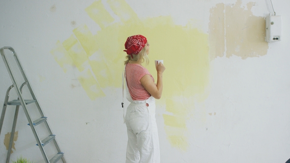 Female Painter with Drink Looking at Wall alt